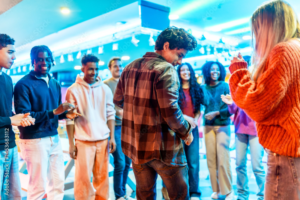 Multiethnic friends playing and having fun at the bowling alley