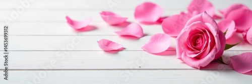 A scattering of pink rose petals on a clean white wooden tabletop , background, white wooden table, flatlay