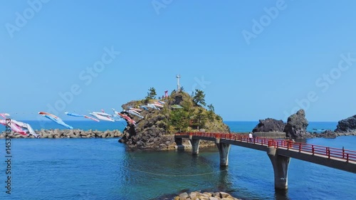 糸魚川市能生の弁天岩と青い海、空に舞う鯉のぼり｜5月の空撮風景
