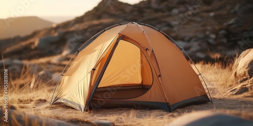 Obraz na płótnie A small yellow tent is set up on a rocky hillside. The tent is open and the sun is shining on it. The scene is peaceful and serene, with the tent providing a sense of shelter w salonie