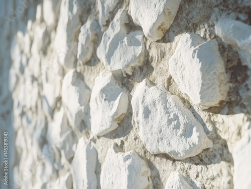 Obraz na płótnie This image features a textured stone wall, possibly made of limestone or marble, with sunlight casting shadows and highlights. w salonie