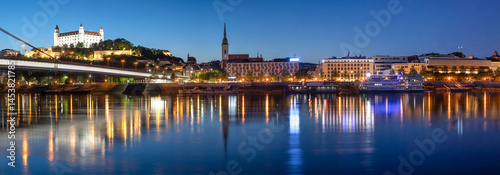Obraz na płótnie Bratislava, Slovakia. Wide angle panoramic city skyline reflecting in water of Danube river at dusk w salonie