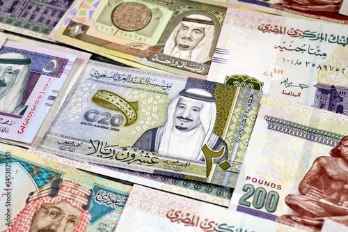 Saudi Arabia riyals SAR cash money bills banknotes and Piles of Egypt money thousands of Pounds currency banknotes bills of 200 EGP LE, Egyptian money exchange rate, economy status, money concept