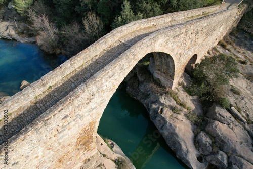 Drone Pedret bridge across LLobregat river on sunny winter day. Berga, Barcelona, Spain.