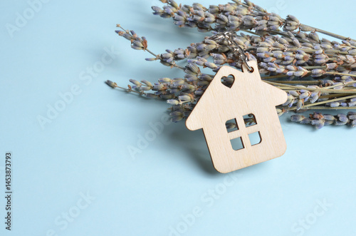 Wooden keychain house and lavender. Blue background.