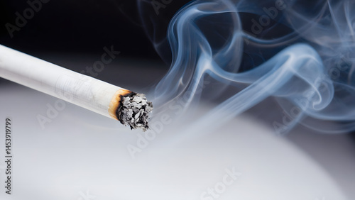 Isolated on a black backdrop, a white smoking cigarette releases toxic tobacco smoke, a visual representation of addiction, unhealthy habit, and the danger of cancer