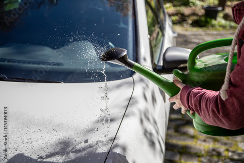 Obraz na płótnie Auto abwaschen mit einer Gießkanne und viel Wasser w salonie