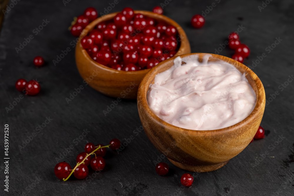yogurt and red currants, a fermented milk product made from milk with the addition of red sweet and sour currants and currant flavor, close up