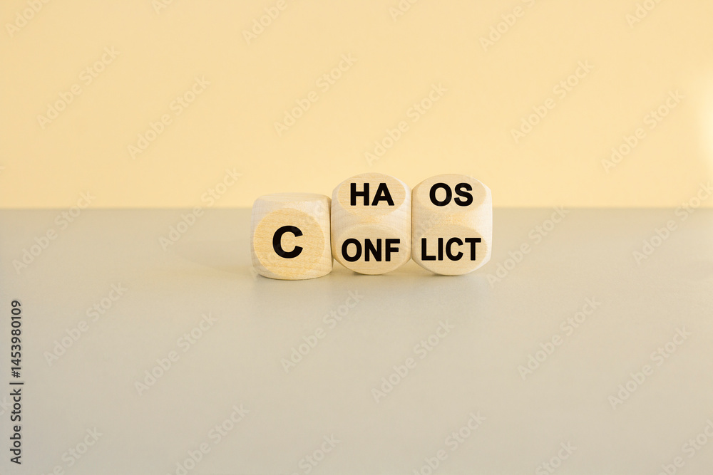 From conflict to chaos symbol. Concept words Conflict and Chaos on wooden cubes. Beautiful gray table beige background. Business Conflict and Chaos concept.