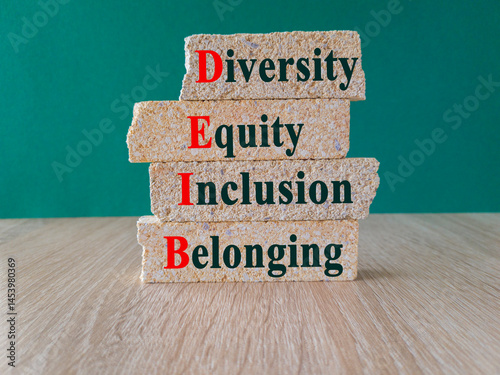 Obraz na płótnie Concept words DEIB diversity equity inclusion belonging on brick blocks. Beautiful green background, wooden table. Business diversity equity inclusion belonging concept w salonie