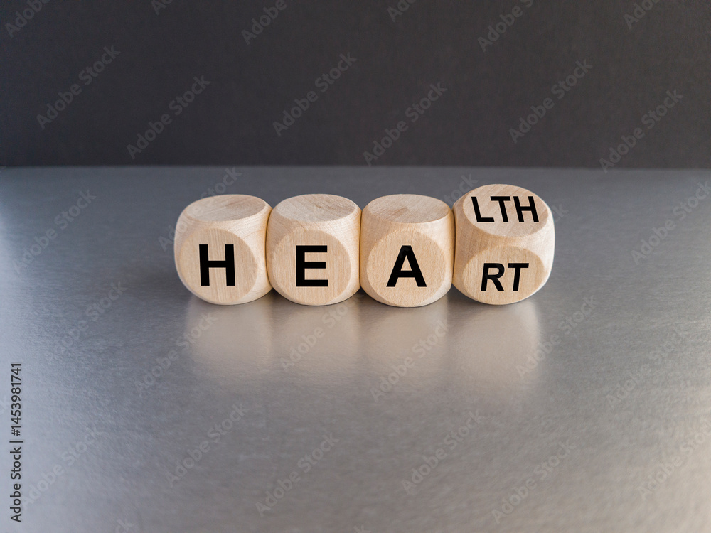 Dice form the words 'heart' and 'health'. Symbol for a heart checkup. Beautiful gray table, black background. Business and medical concept.