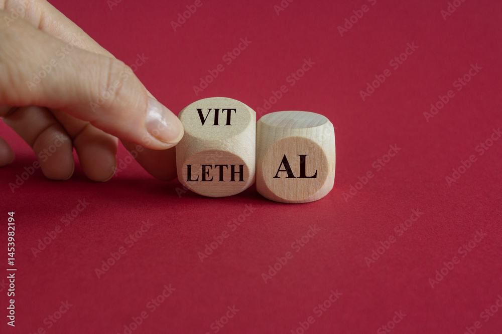 Vital vs lethal symbol. Businessman turns wooden cubes and changes the word 'lethal' to 'vital'. Beautiful red background. Business and vital vs lethal concept.