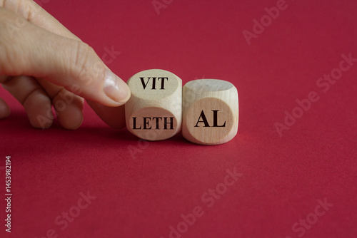 Obraz na płótnie Vital vs lethal symbol. Businessman turns wooden cubes and changes the word 'lethal' to 'vital'. Beautiful red background. Business and vital vs lethal concept. w salonie