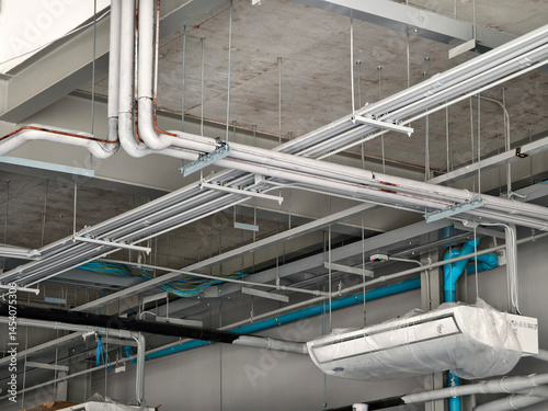 The ceiling of a large building under construction an extensive network of pipes