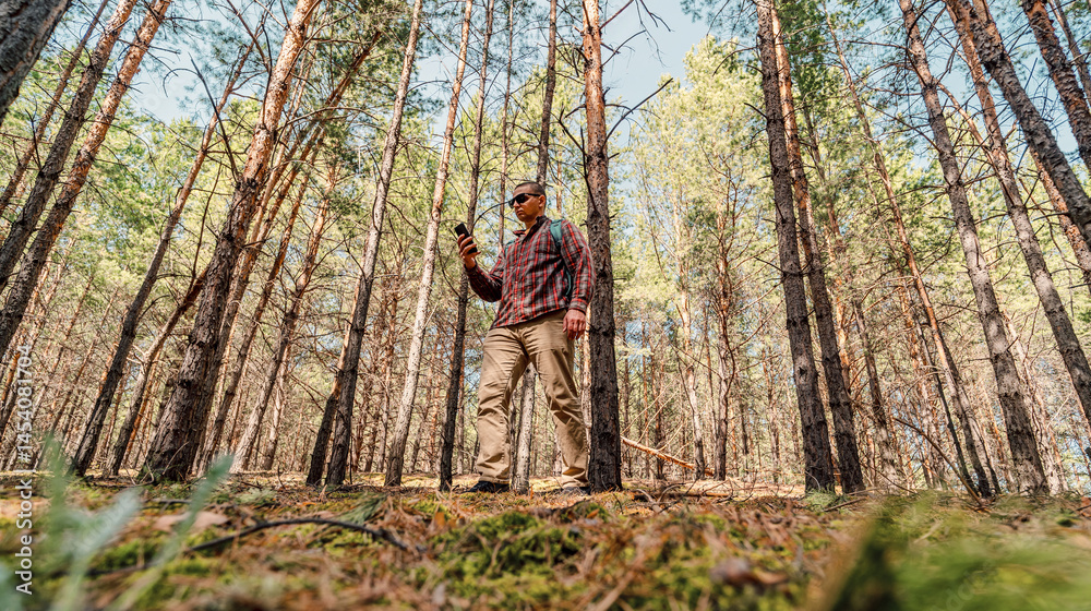 hiker man using smart phone in the forest