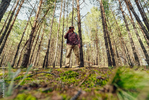 Obraz na płótnie Man using phone in the wild w salonie