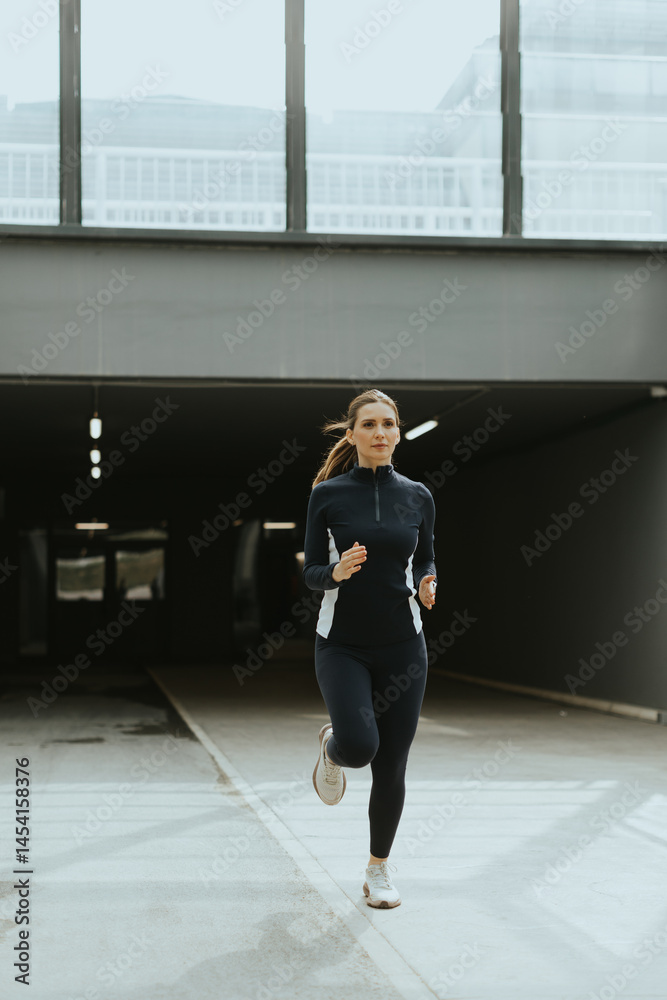 Dynamic jogger embraces urban solitude while navigating a sleek tunnel in morning light