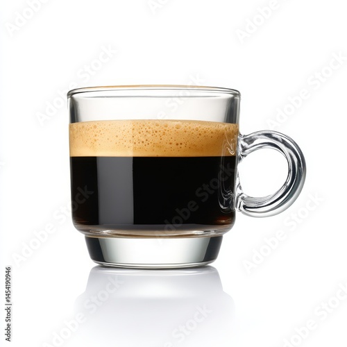 Close up shot of a glass coffee cup filled with dark liquid and foamy crema layer