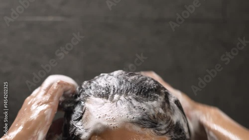 A man washes his hair with anti-dandruff shampoo. photo
