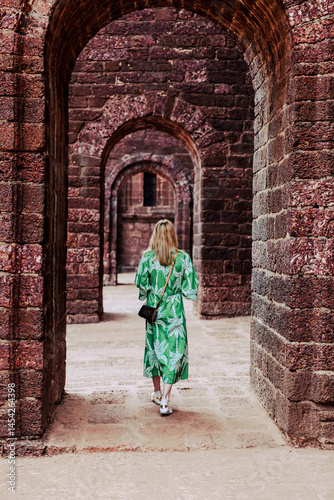 Photography Goa, India - February 20, 2025: A woman walking and taking photos outside of the