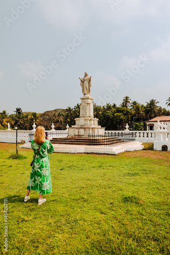 Photography Goa, India - February 20, 2025: A woman taking a photo of the Statue of Jesus outside the Se Cathedral and Church of St