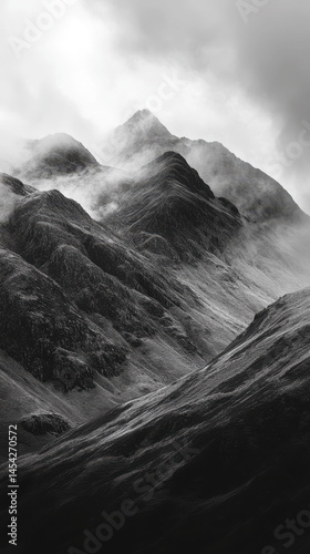 Majestic mountains shrouded in mist under overcast skies in a remote landscape