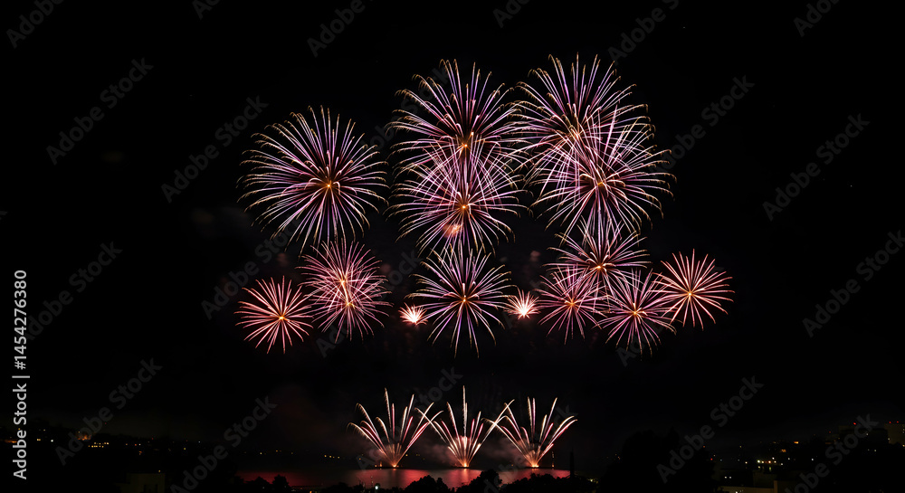 Fototapeta premium Spectacular Night Sky with Colorful Fireworks Display Over Water