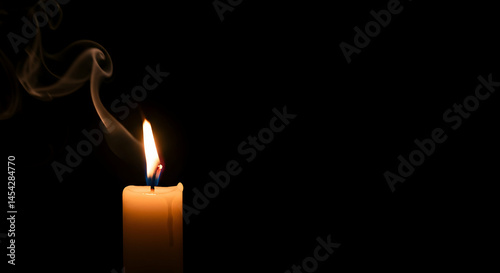 Single Candle Flame with Smoke Against Black Background