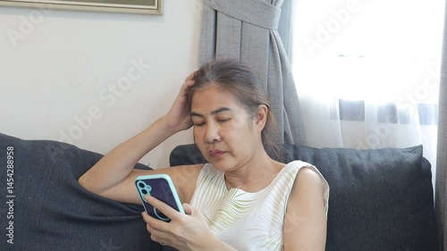 Woman sitting on sofa and looking at her phone.