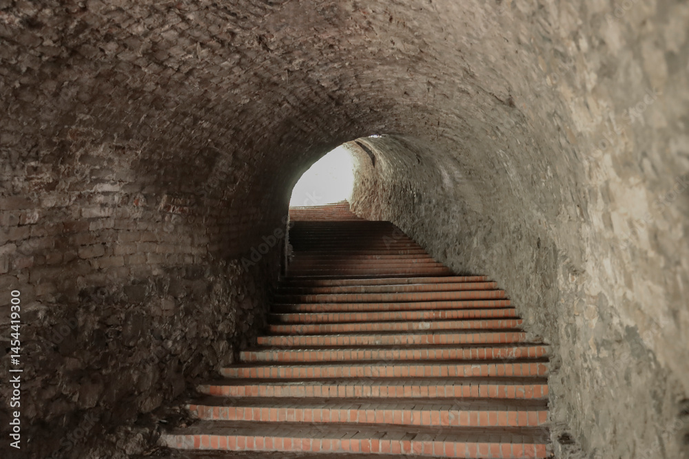 Obraz premium Stairs ladder leading to the Petrovaradin Fortress, Novi Sad, Serbia. Stone steps and archway. tunnel arches with stairway up perspective.