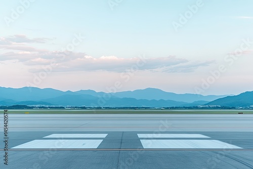 Empty airport tarmac at dawn, mountains in the distance