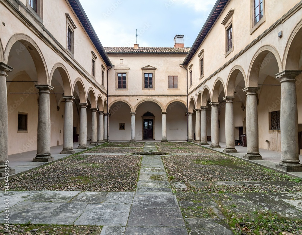 Obraz premium Serene courtyard with stone columns and arches. A peaceful architectural scene.