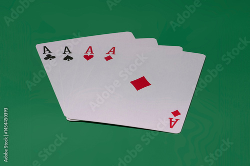 Close-up of four ace cards on a green background.