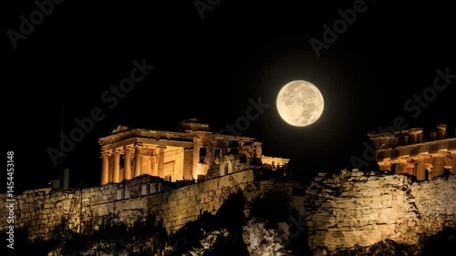Full moon over Ancient Greek temple ruins, classical building on a rocky hill illuminated, dark sky 