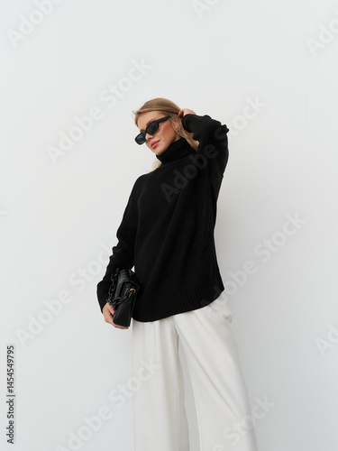 Stylish model showcases contemporary fashion in a modern studio setting