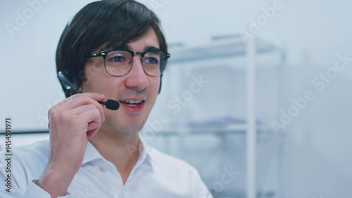 Concentrated caucasian businessman, IT support whit headset giving support to customer at Virtual help desk in office. Focused Male call center working with clients at help desk for customer support.