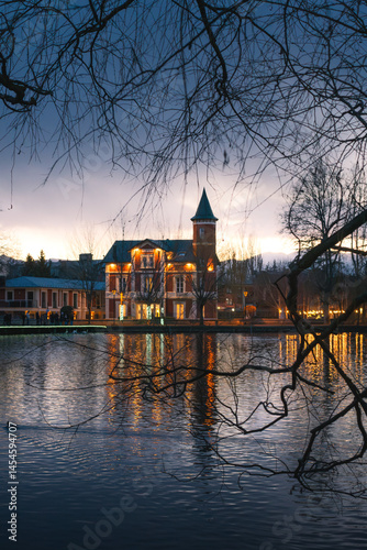 Elegant Historic Building by a Lake at Dusk – Reflections and Winter Trees Framing the Scene