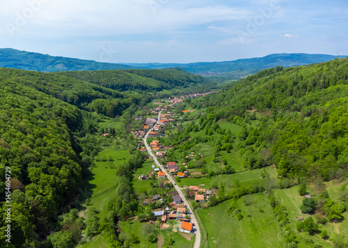 Aerial view of a village between hills with forests in Transylvania - Romania