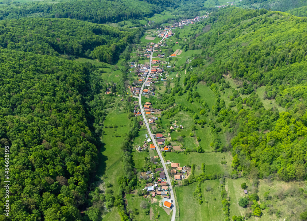 Landscape of a village in a valley between hills seen from above. Aerial view of a village in Transylvania - Romania