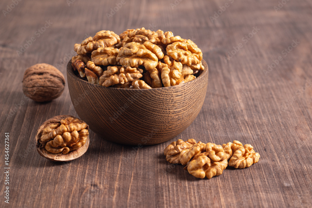 Walnuts nuts in a bowl on wooden background Walnuts nuts in a bowl on wooden background