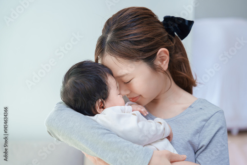 赤ちゃんを抱いて祈るような表情の女性