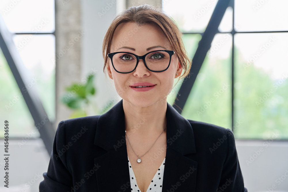 Headshot portrait of middle-aged serious business woman in office