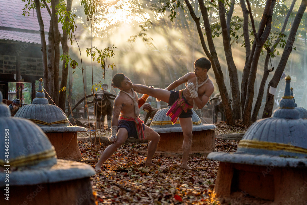 Fototapeta premium Traditional Muay Thai Fighters Training in Forest Temple. Martial Artists Practicing Kickboxing at Sunset in Rural Thailand.