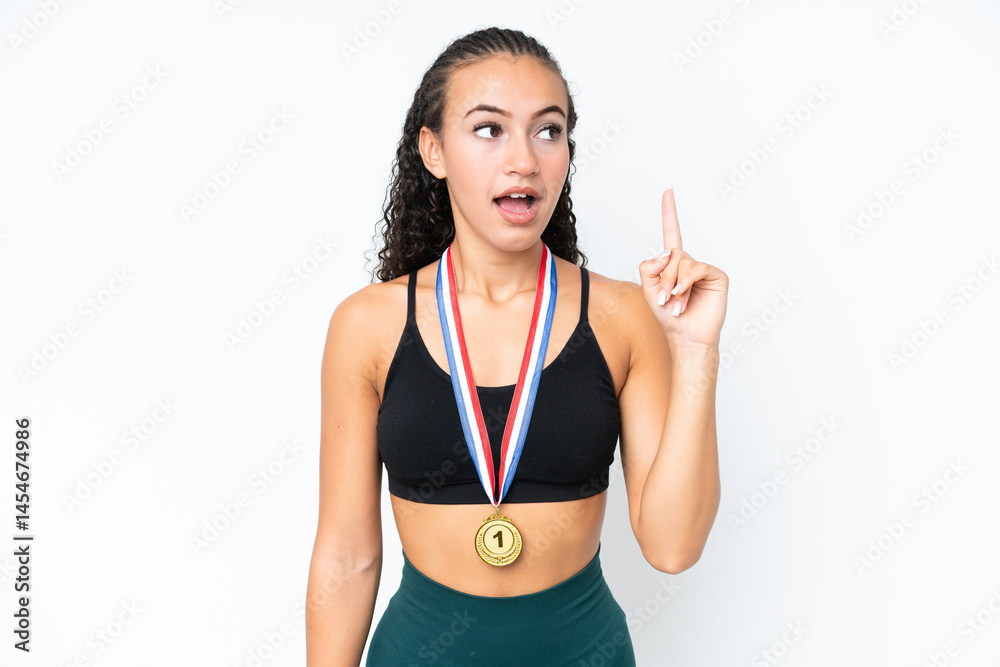 Young sport woman with medals isolated on white background thinking an idea pointing the finger up Young sport woman with medals isolated on white background thinking an idea pointing the finger up