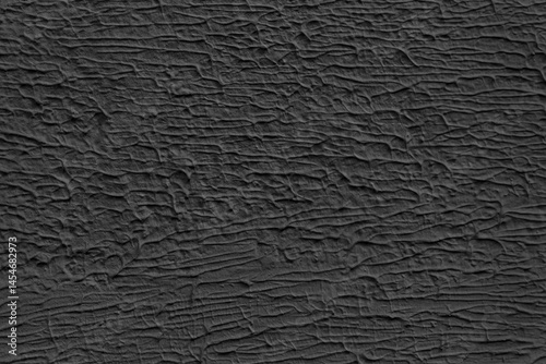 A wall with a black paint that has a texture. The texture is made up of lines and swirls.
