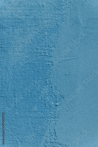 A wall with a blue color and a rough texture. The wall has a few scratches and marks.