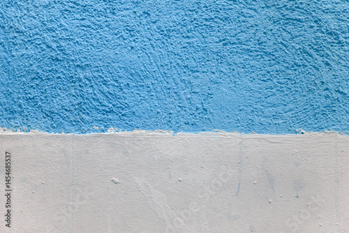 A wall with a blue and white stripe. The blue stripe is painted on top of the white.