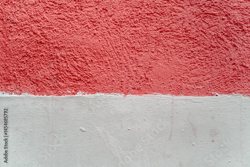 A wall with a red and white stripe. The yellow stripe is painted on top of the white.