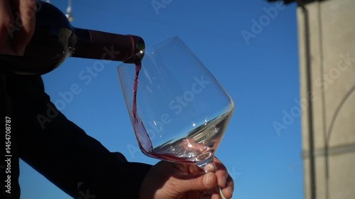 Sommelier pours red wine into crystal glass. Slow motion video