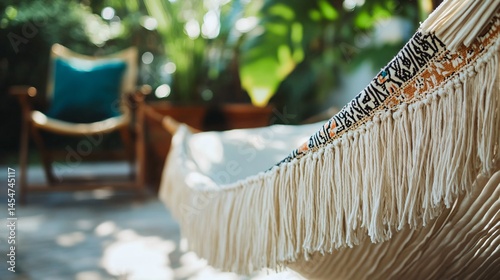 Obraz na płótnie Close up of hammock edge with fringe gently blowing in wind, vintage chair and plant in background w salonie